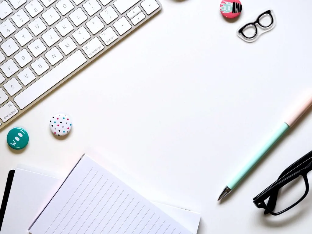 Keyboard, paper, small black eye glasses, blue pen, work station, desk area. www.everythingabode.com Affiliate Strategy