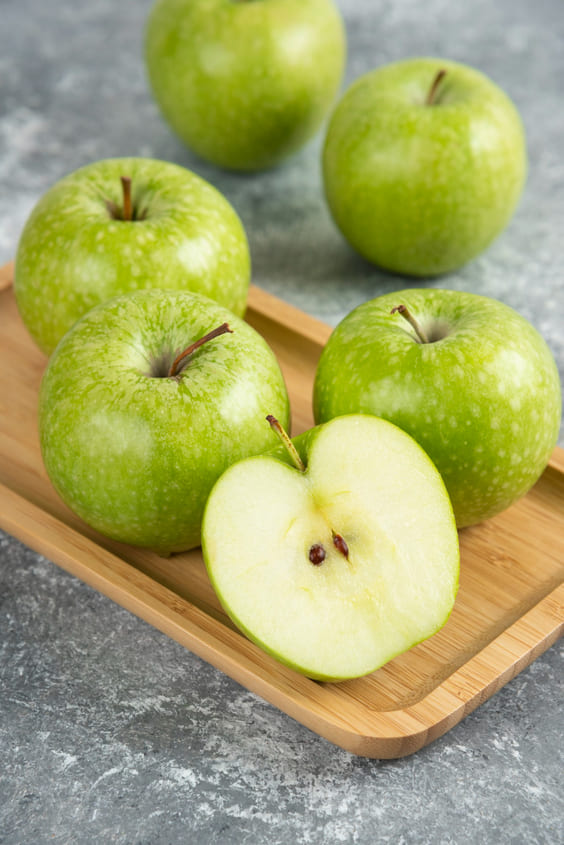 green apples on wooden cutting board