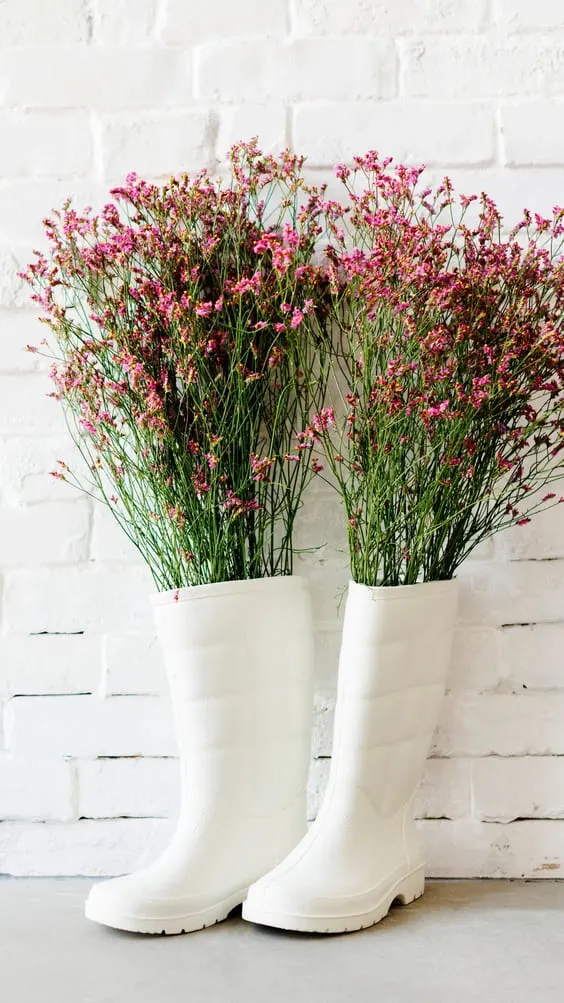 pretty pink wildflowers placed in white rainboots wallpaper.