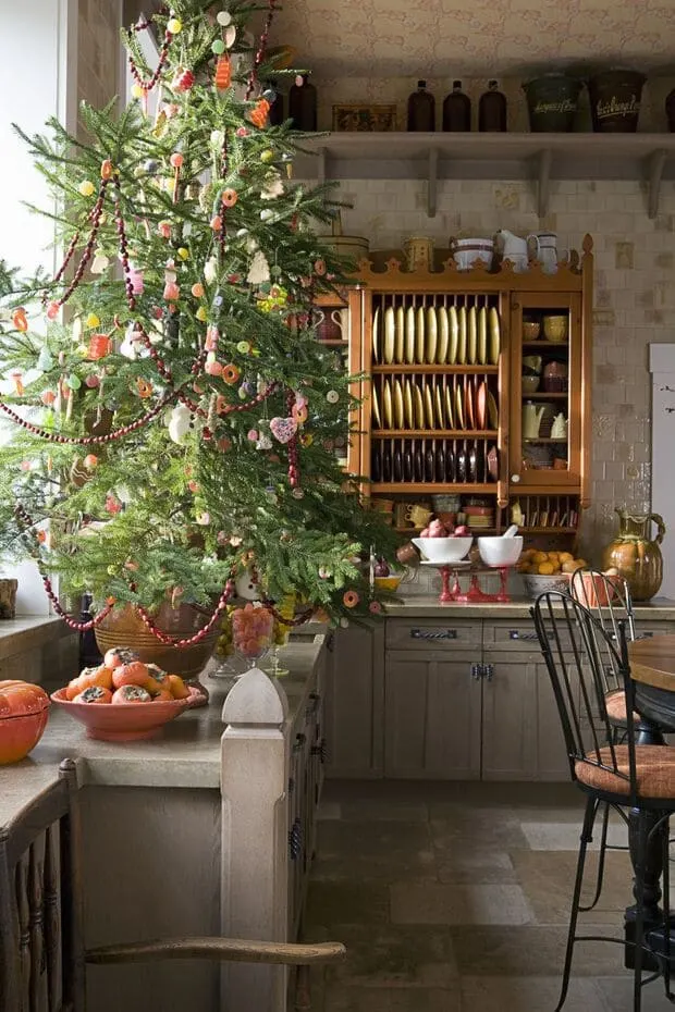 a Mini Tree in a Christmas Theme in front of the kitchen window