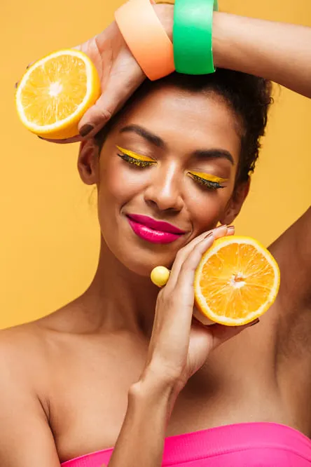 how to get dopamine naturally, women holding two sliced oranges smiling