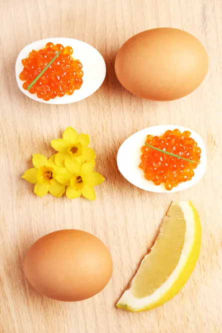 A composition of eggs and red caviar and flowers over natural background, protein to help increase dopamine naturally