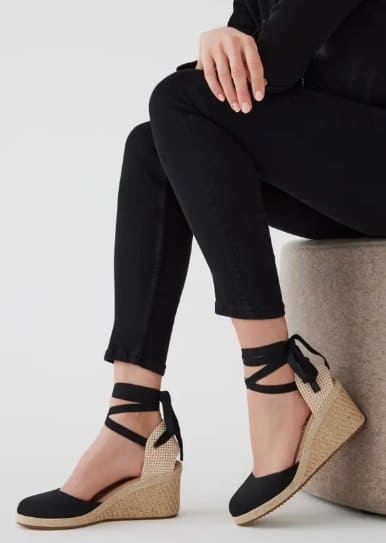 Sophisticated black tie-up espadrille wedges paired with sleek black pants