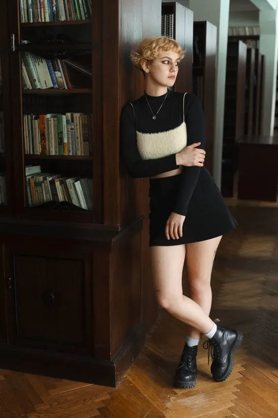 dark academia outfit inspiration of an woman wearing a dark academia outfit in a library