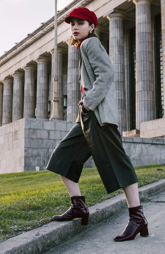 a woman wearing a dark academia outfit in a park outside