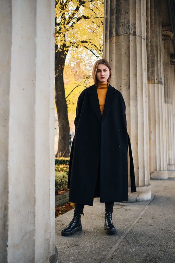 a woman wearing a dark academia outfit at a museum 