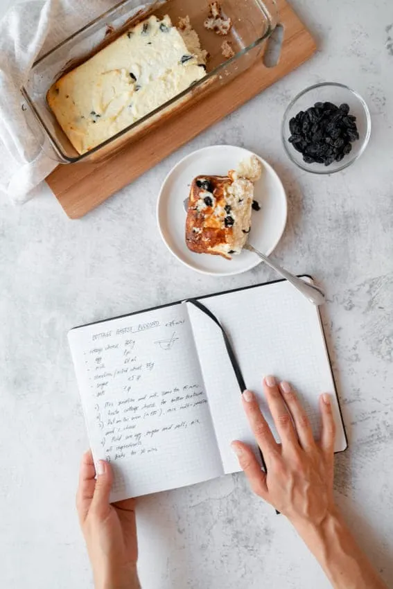 woman journaling with pastry and coffee