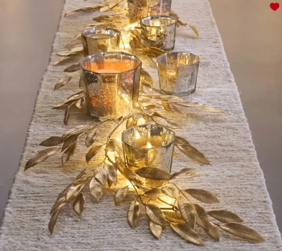 Gold leaf table runner with votive candles.