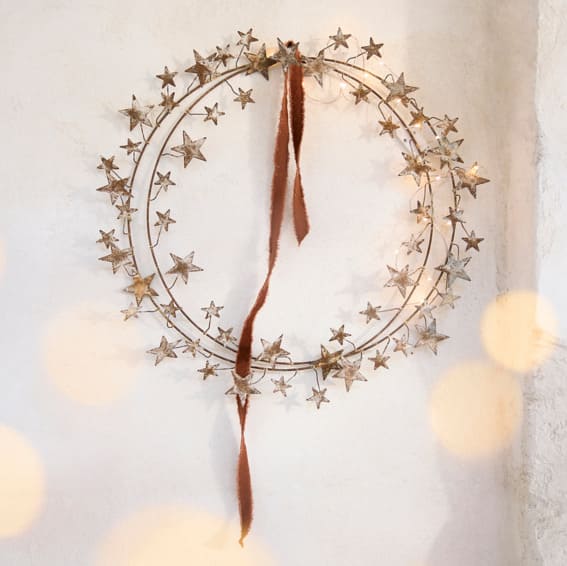 A starry wire wreath with a velvet ribbon.