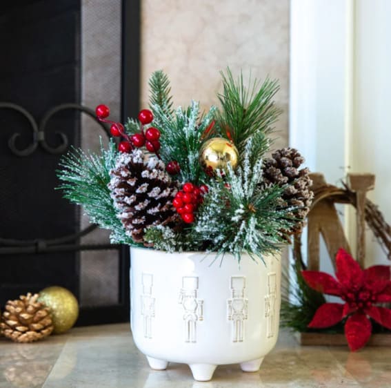 Festive holiday arrangement in a Nutcracker-themed pot.