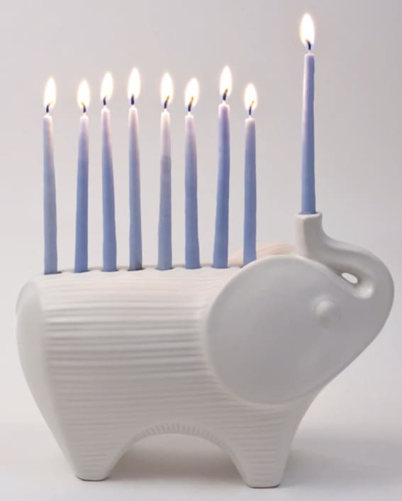 Ceramic elephant menorah with blue candles.