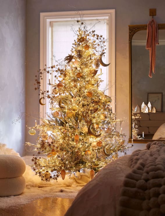 Golden celestial-themed Christmas tree with a glow