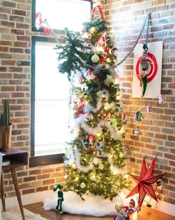 Mischievous Elf on the Shelf decorates the Christmas tree.