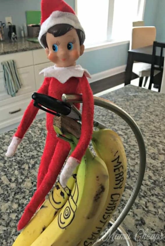Elf on the Shelf writes a merry message on a banana.
