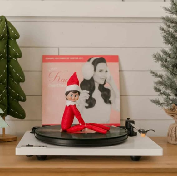 Elf on the Shelf enjoying Christmas tunes on vinyl.