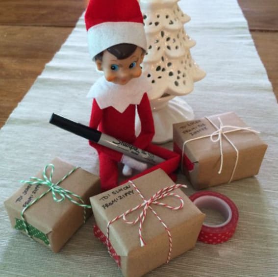 Elf on the Shelf prepares tiny gift packages, ready for festive fun.