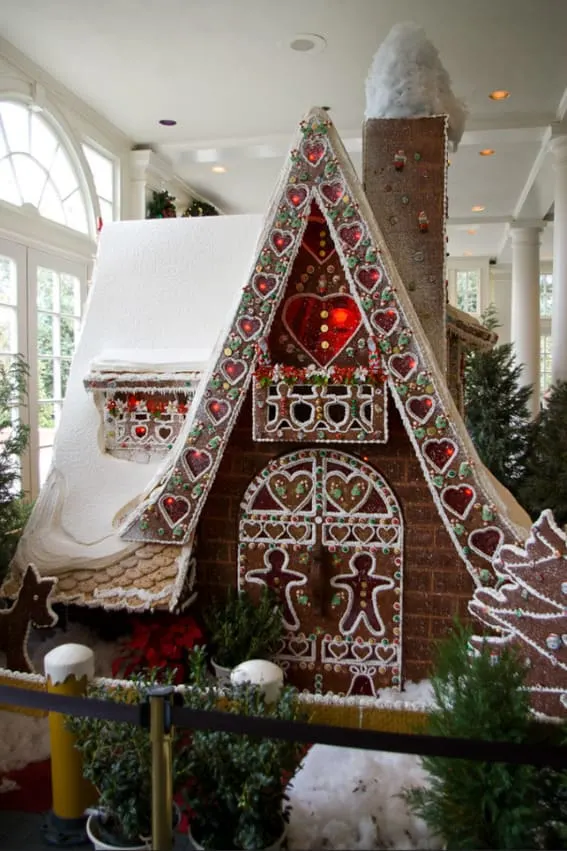 An intricate gingerbread cathedral with elaborate icing designs and a tall glowing interior.