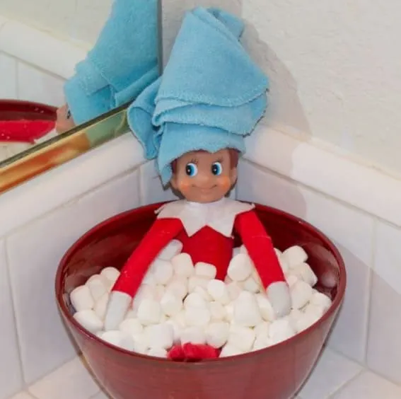 Elf on the Shelf enjoys a marshmallow bath with a towel turban.