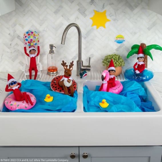 Elves throw a tropical pool party in the kitchen sink.