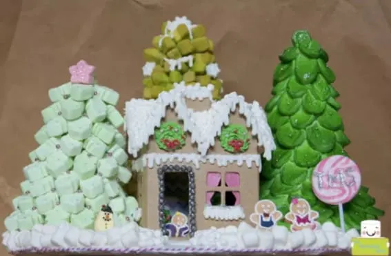 A gingerbread house scene with marshmallow trees and festive candy decorations.