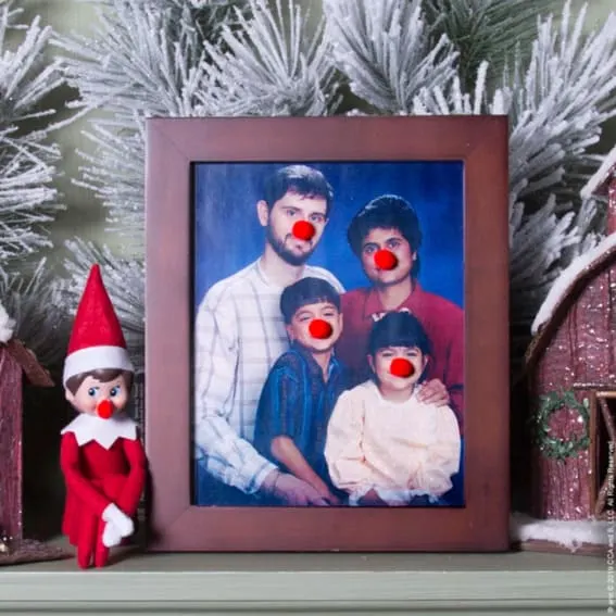 Elf on the Shelf adds red clown noses to a family portrait.