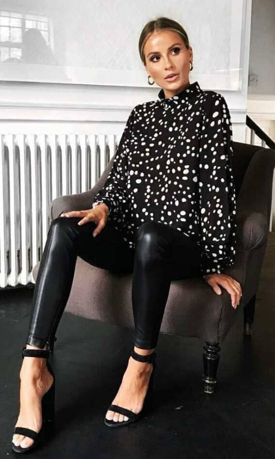 A chic polka dot blouse juxtaposed with the edge of black leather pants creates a playful yet poised look