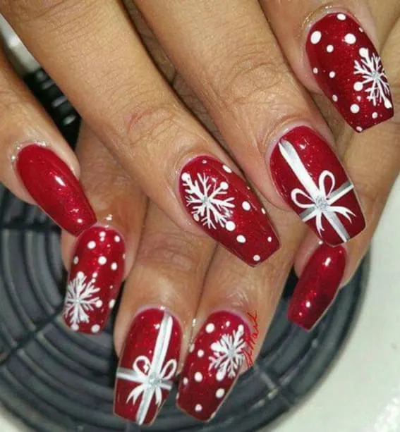 Short nails with red base and white snowflake and bow art