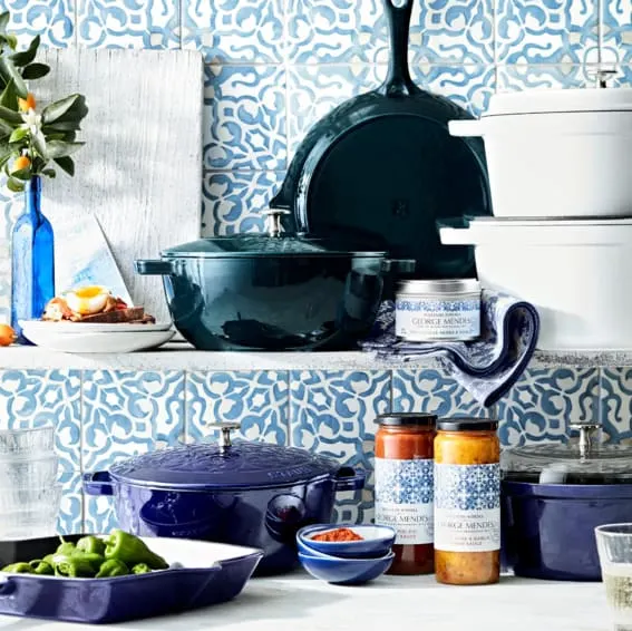 A Staub enameled cast iron French oven with lily embossing on a dinner table.