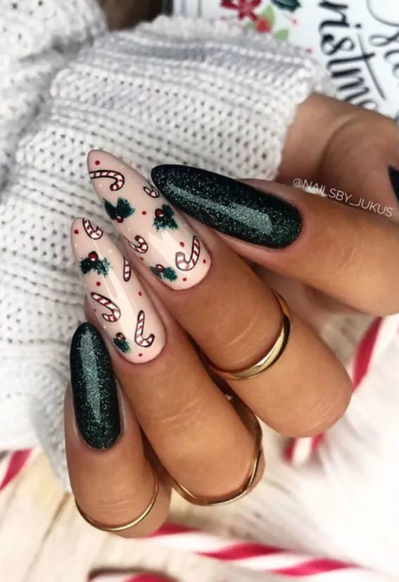 Christmas nails with candy cane and holly berry designs on a nude base, paired with a sparkling dark green nail
