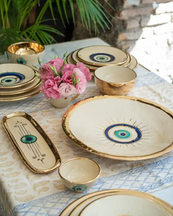 An opulent tableware set with eye motifs and gold accents.
