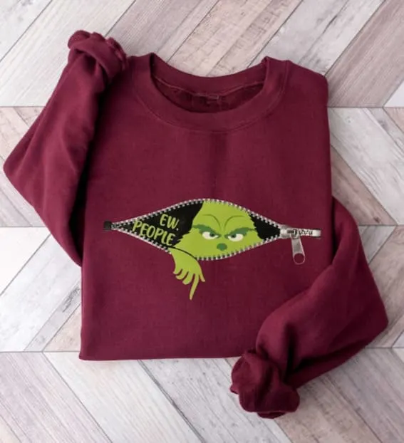 Maroon sweatshirt with Grinch graphic, perfect for the Christmas-loving introvert.