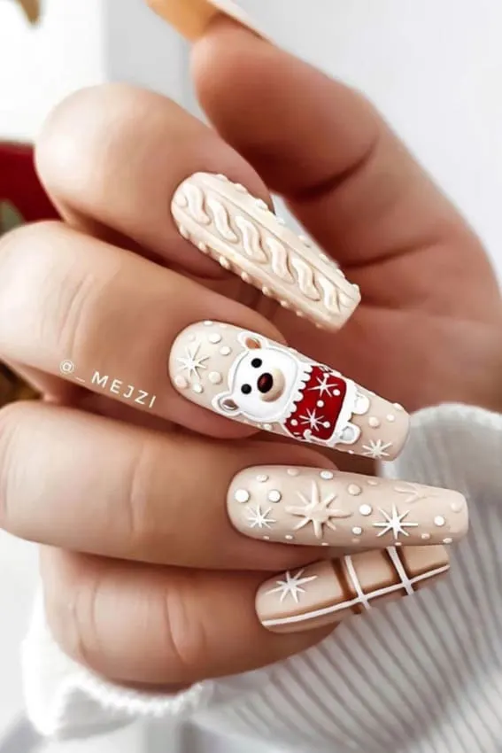 Beige nails with a knit pattern, a cheerful polar bear, and snowflake details.