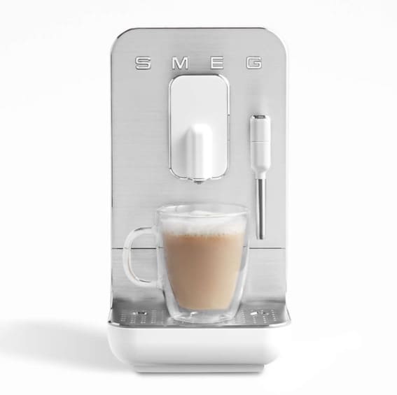 A stylish Smeg coffee and espresso machine with a frothy coffee cup.