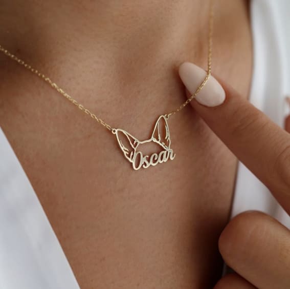 Custom gold necklace with dog's name and ears, a heartfelt gift for pet owners.