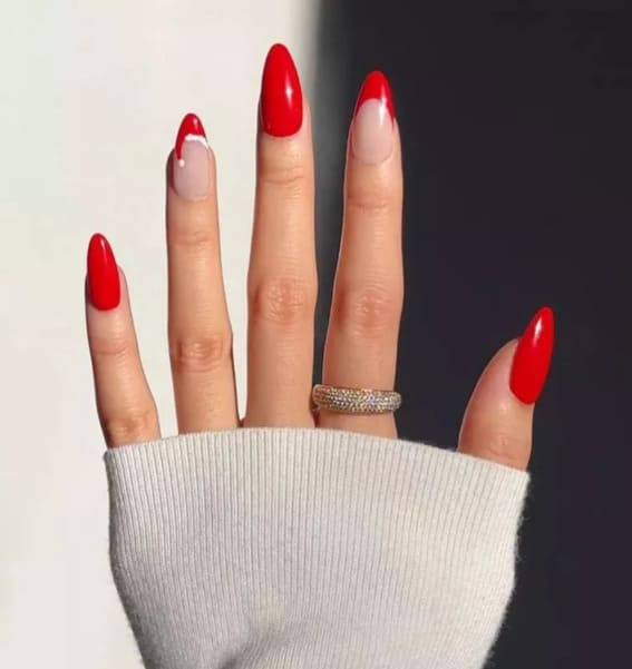 Red stiletto nails with a single accent nail featuring a red and white French tip.