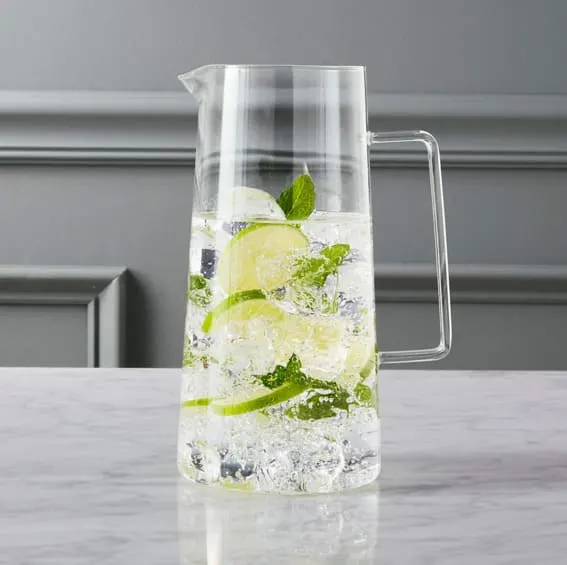 A refreshing pitcher filled with ice, lime slices, and mint leaves.