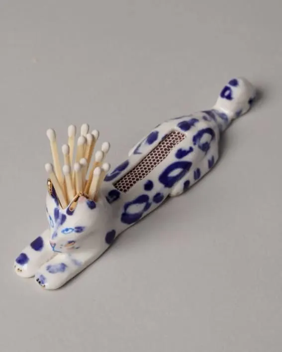  A Dalmatian-patterned matchstick holder on grey counter.