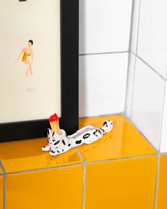  A Dalmatian-patterned matchstick holder on a tiled counter.