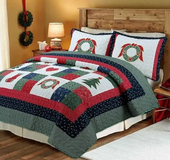 A festive quilt bedding set with wreaths, pine trees, and stockings.
