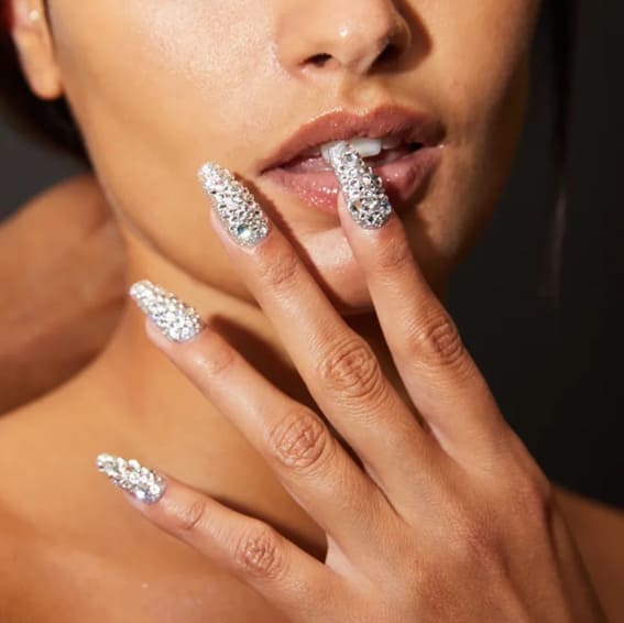 Stiletto nails fully adorned with shimmering rhinestones.