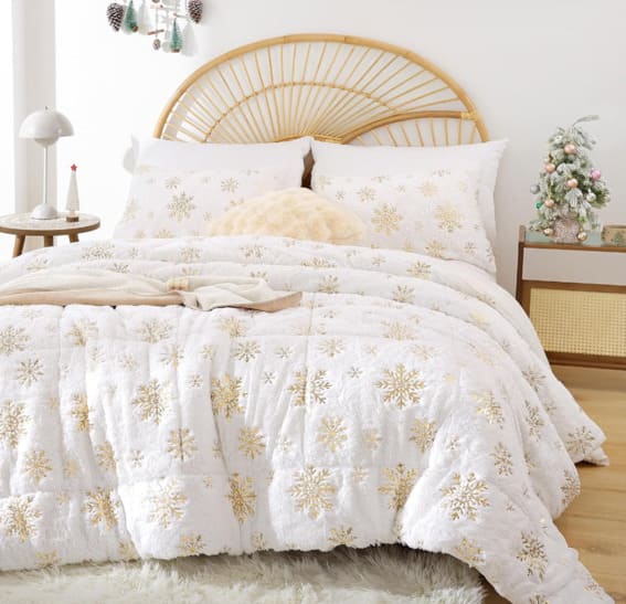 A white and gold snowflake queen comforter set with pillowcases.