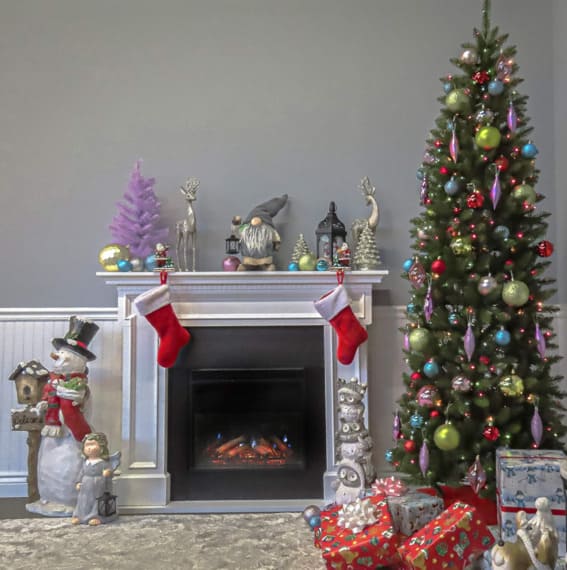 A 6.5-foot National Tree Company artificial pre-lit slim Christmas tree with multicolor lights and stand, styled in a modern living space.