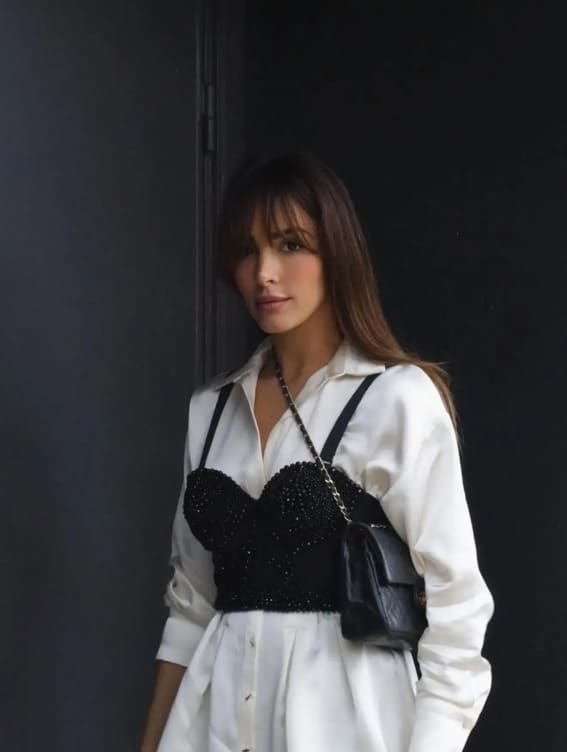 Outfit featuring a black sequined bustier over a crisp white blouse, creating an elegant layered look.