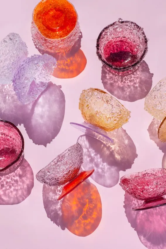 A collection of iridescent glassware casting colorful shadows.