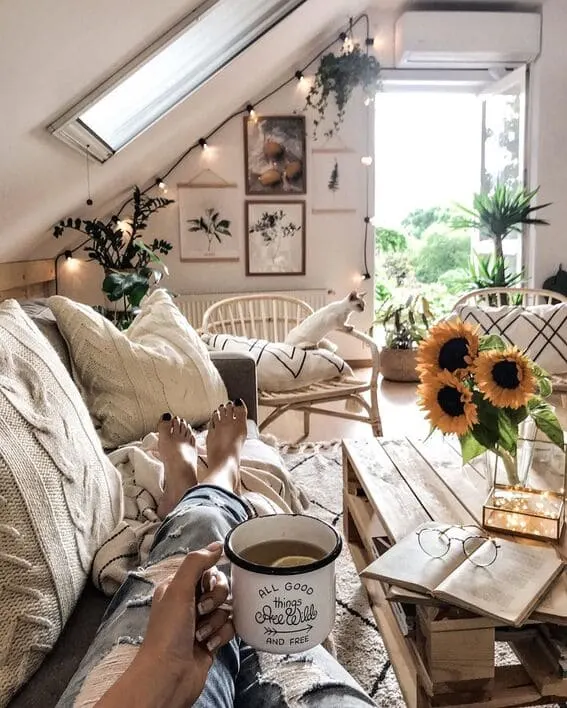 Cozy attic reading nook with sunflowers and string lights, perfect for a relaxed afternoon.