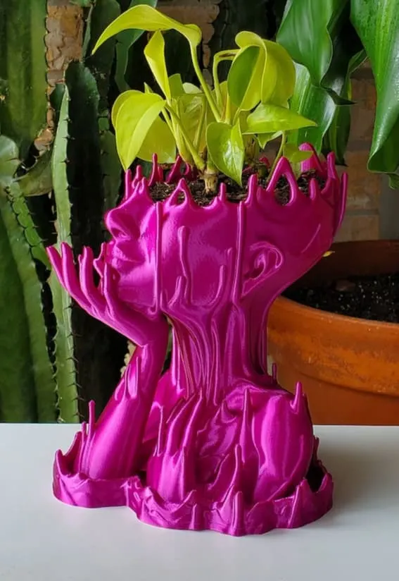 A pink 3D printed planter with a striking, artistic Medusa design.