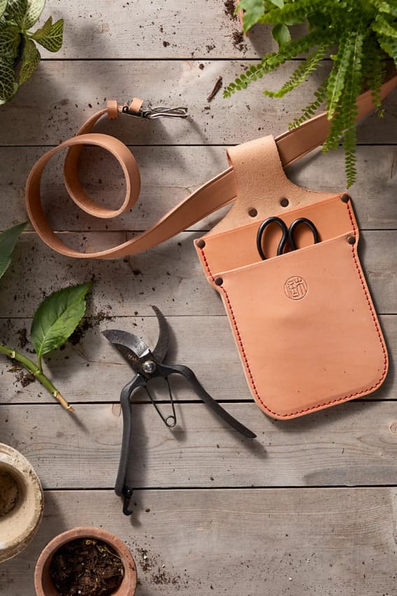 A handcrafted leather holster housing premium gardening tools.