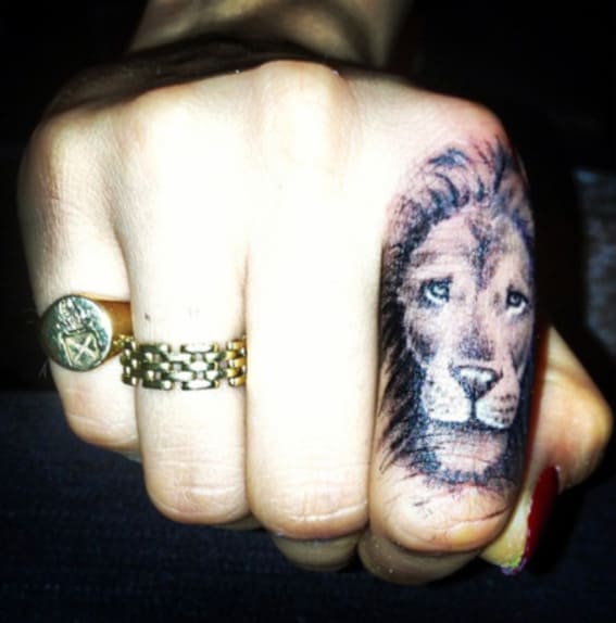 A detailed lion tattoo on the index finger