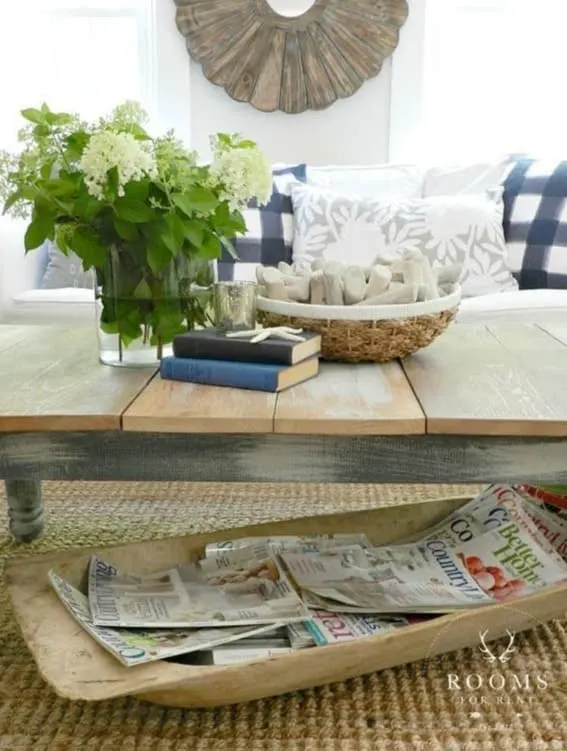 Dough bowl under a coffee table holding assorted magazines