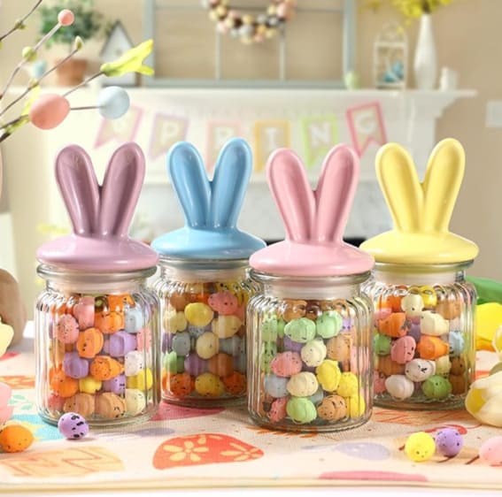 Set of four glass jars with pastel-colored ceramic bunny ear lids.